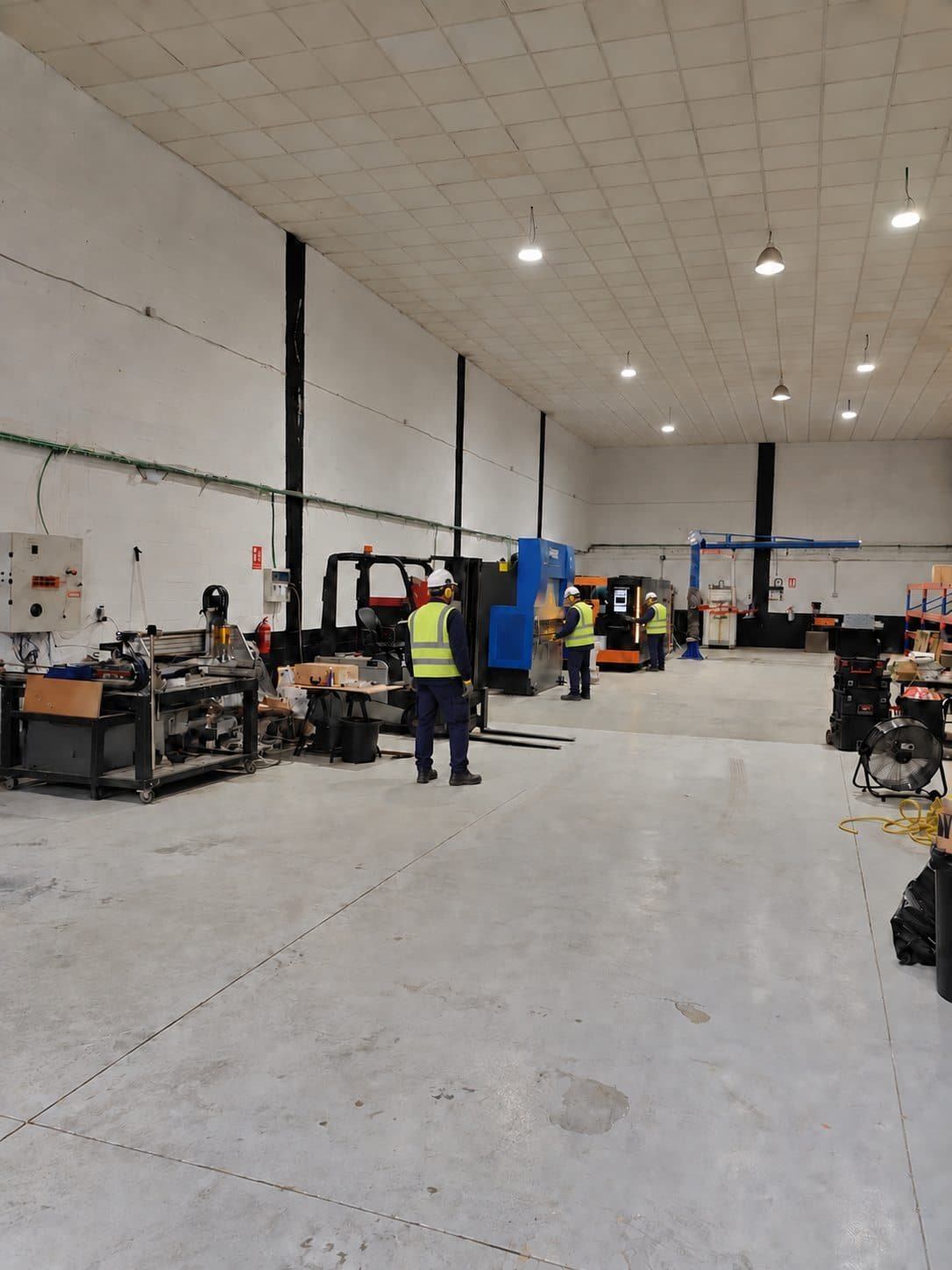 Tres operarios con equipos de protección individual en las instalaciones de MetalCut360
